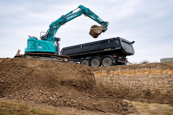 Bagger beim Beladen eines LKWs mit Aushub der Baugrube nähe Nürtingen