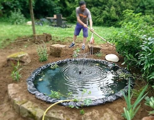 Arbeiter beim Gestalten eines Teiches im Garten- und Landschaftsbau in Nürtingen