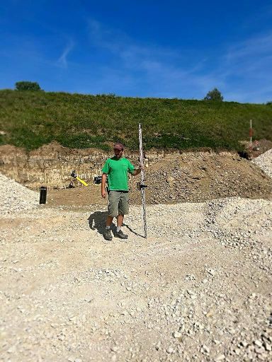 Arbeiter beim Vermessen der Baugrube mit Laser